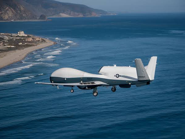 Military unmanned aerial vehicle in flight over operational terrain